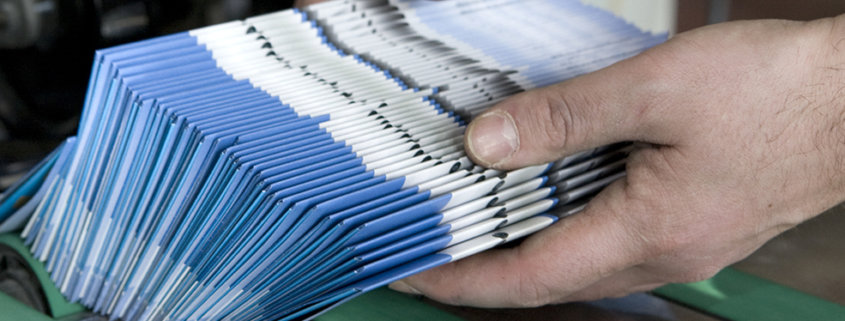 Hand holding a packet of brochures