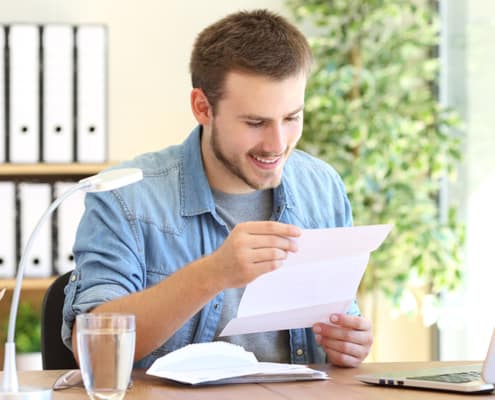 Man with big smile reading mail