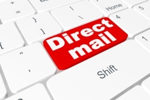 Bright red key that says direct mail on a white keyboard