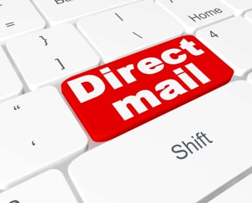 Bright red key that says direct mail on a white keyboard