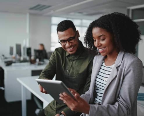 Coworkers joyfully looking at a tablet