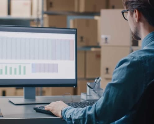 Man looking over datasets on his monitor