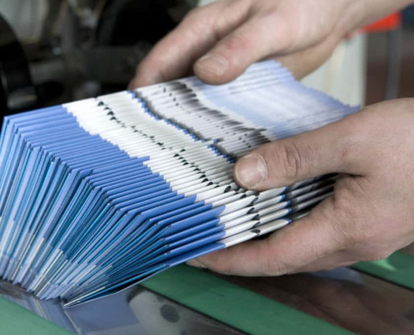 Close up view of a person sorting brochures