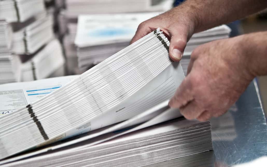 Close up view of a person sorting through flyers