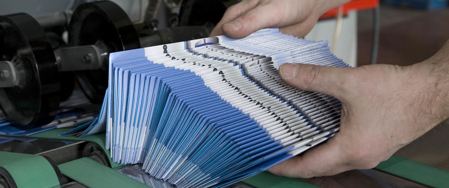 View of a person grabbing a bundle of brochures