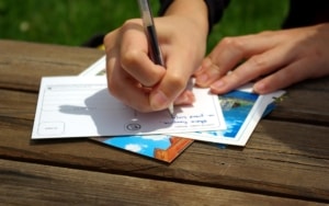 Close up view of person filling out postcard