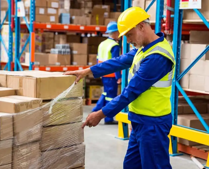Distribution worker looking over pallet of boxes