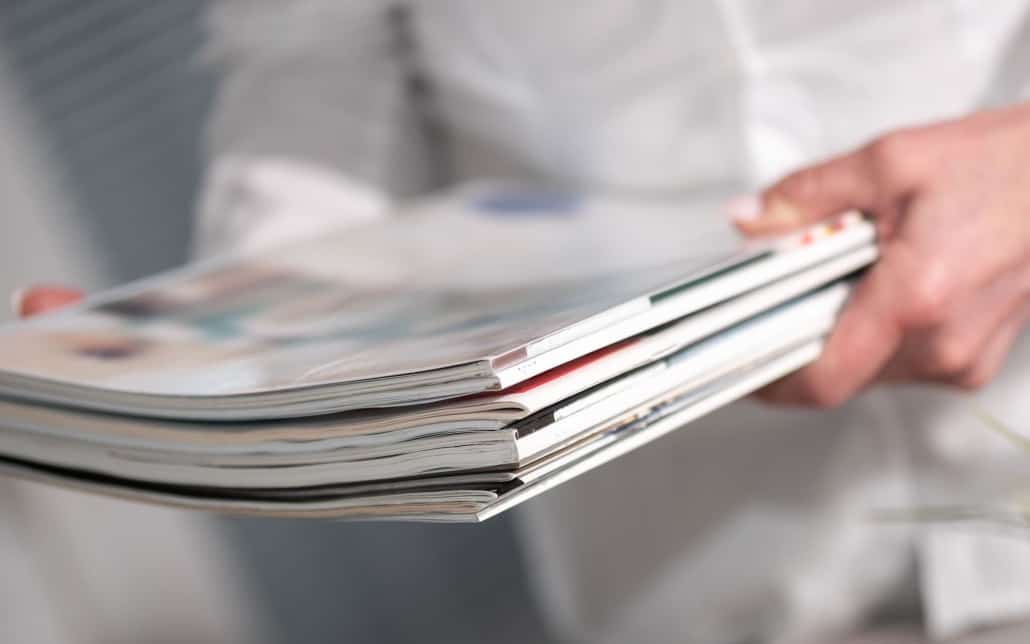 Person holding a stack of catalogs