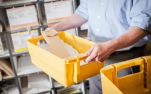 Postage metering worker carrying letters