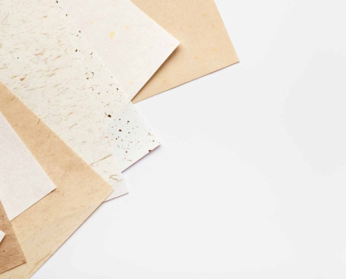 Stack of different handmade paper on a white background