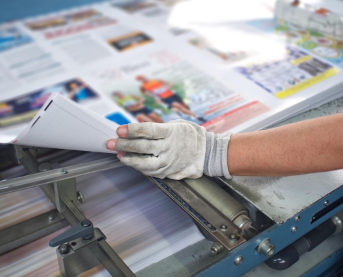 Worker analyzing magazine prints.