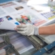 Worker analyzing magazine prints.
