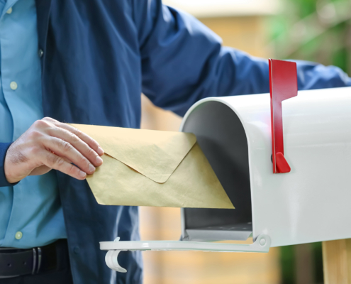 postman putting letter in mail box