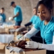 Volunteer worker looking through packages of donations for charity