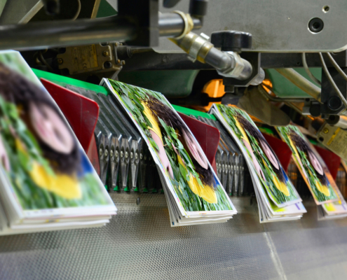 Brochure and magazine stitching process. Close-up of the offset conveying process of a full-automatic stitching unit