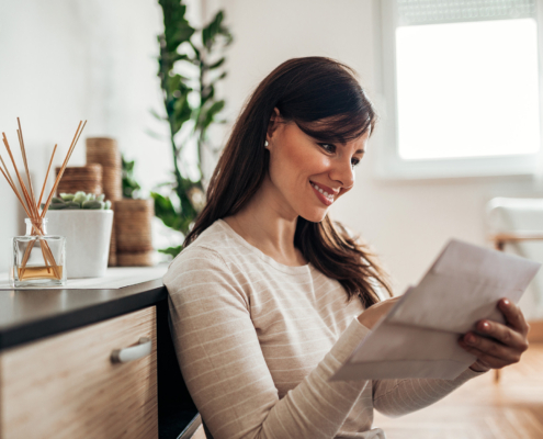 Portrait of a beautiful woman checking mail at home