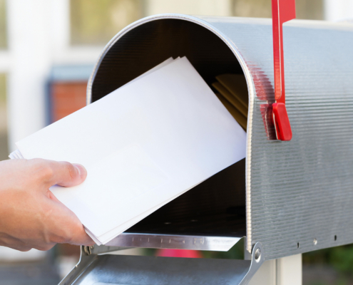 Person putting mail in mailbox