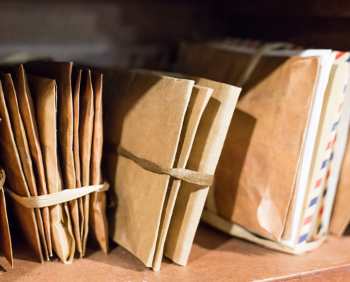 Stack of old letters on a wooden bookcase